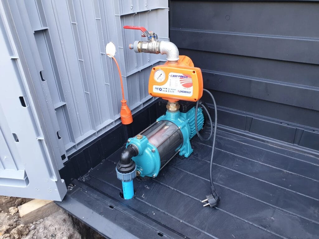 Pompa hydroforowa (np. Leader / Pedrollo) z automatem Pedrollo EASY PRESS (pomarańczowy), zainstalowana w plastikowej obudowie ogrodowej (Keter).