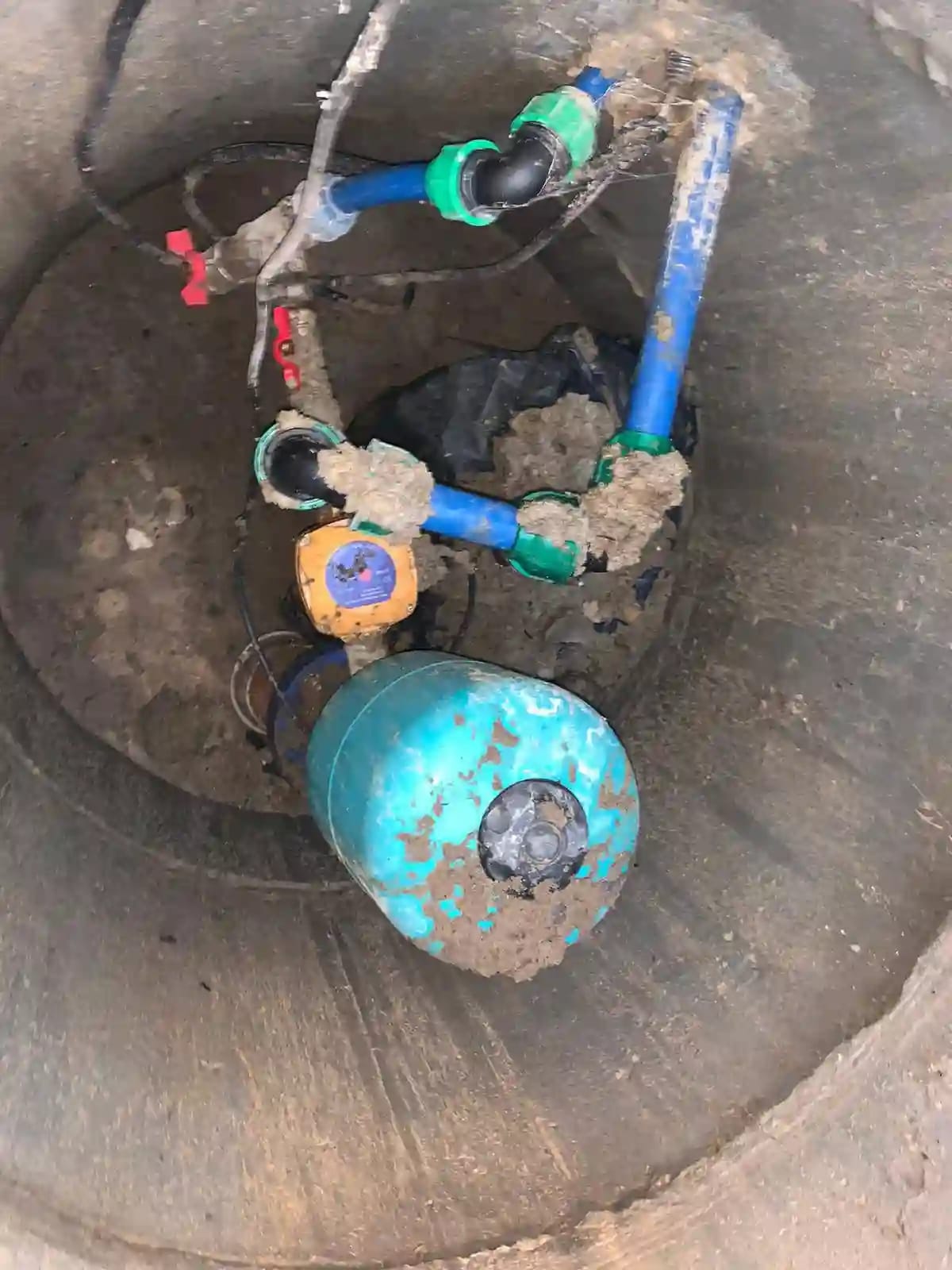 Katastrofalny błąd montażowy: osprzęt pompy głębinowej (elektroniczny automat i zbiornik przeponowy) zainstalowany w błotnistej studni kręgowej.