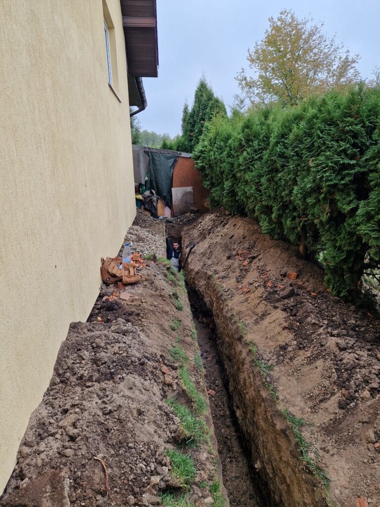 Instalator Hydromonters.pl w głębokim wykopie (poniżej strefy przemarzania), układający przyłącze wodne PE od studni do budynku.