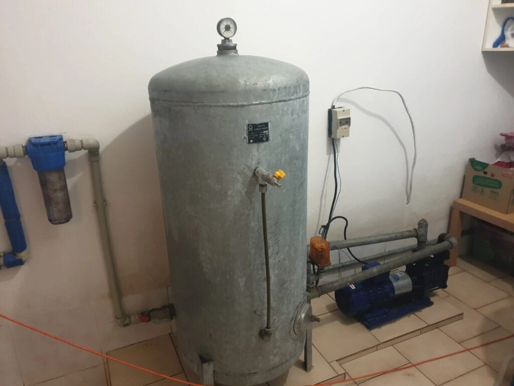 Głośny, archaiczny zestaw hydroforowy: pompa Hydro-Vacuum SKA, zbiornik ocynkowany i krytyczny błąd w postaci filtra na rurze ssącej.