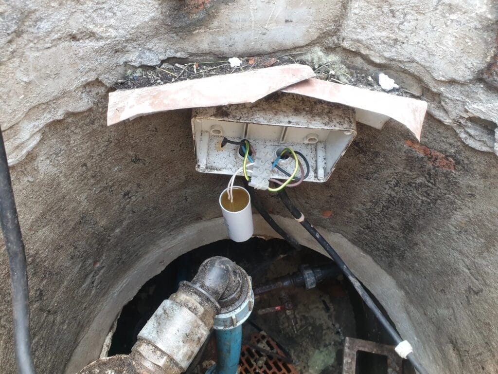 Kardynalny błąd: kondensator rozruchowy pompy głębinowej zainstalowany w puszce w wilgotnej studni, z pominięciem zabezpieczenia termicznego.