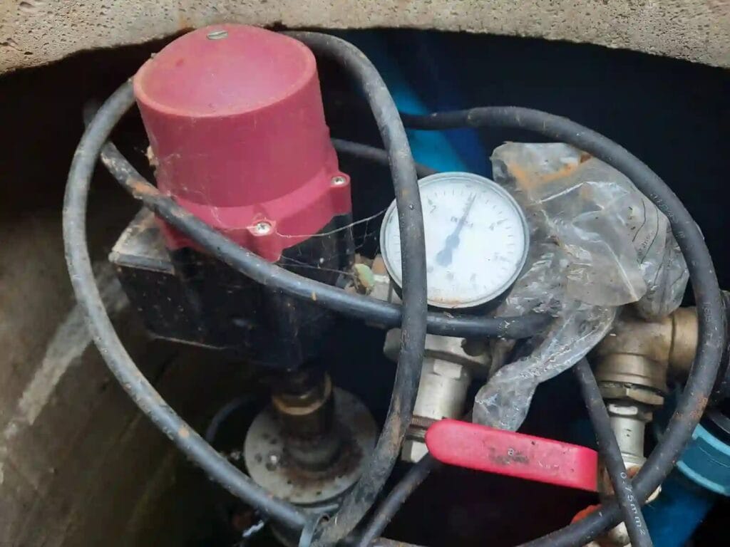 Krytyczny błąd montażowy: elektroniczny automat sterujący Brio SK-13 i manometr zainstalowane w wilgotnej, brudnej studni kręgowej.