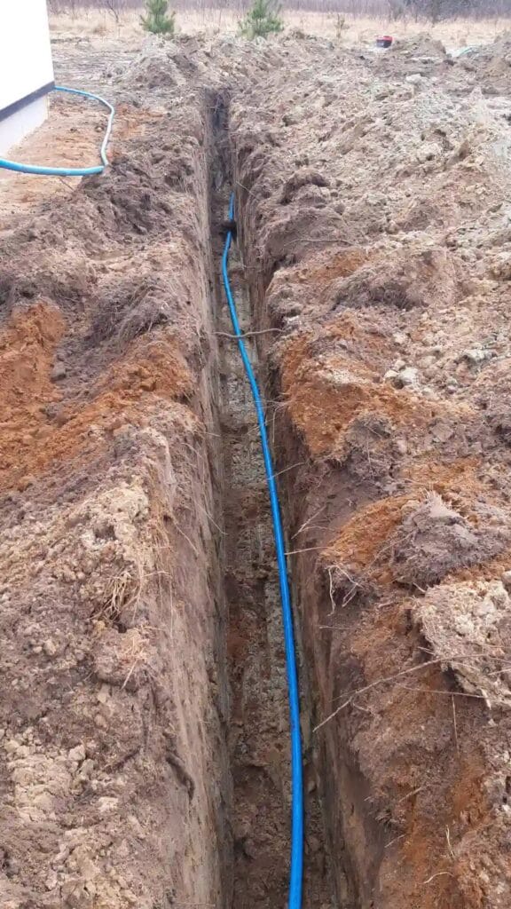 Perfekcyjnie prosty, długi i głęboki wykop (tranzyt) dla niebieskiej "arterii" wodnej (rury PE), łączącej ujęcie Hydromonters.pl z budynkiem.