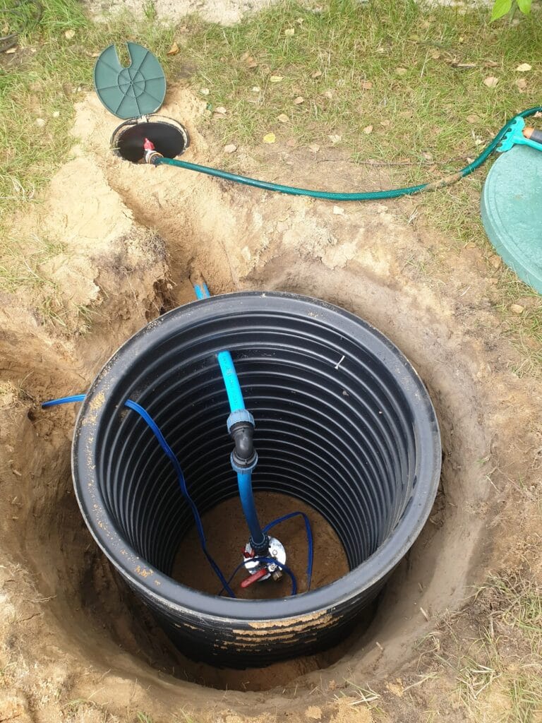 Hermetyczna głowica studni głębinowej z mosiężnym rozdzielaczem, zainstalowana na dnie głębokiej, suchej komory rewizyjnej (rura karbowana).