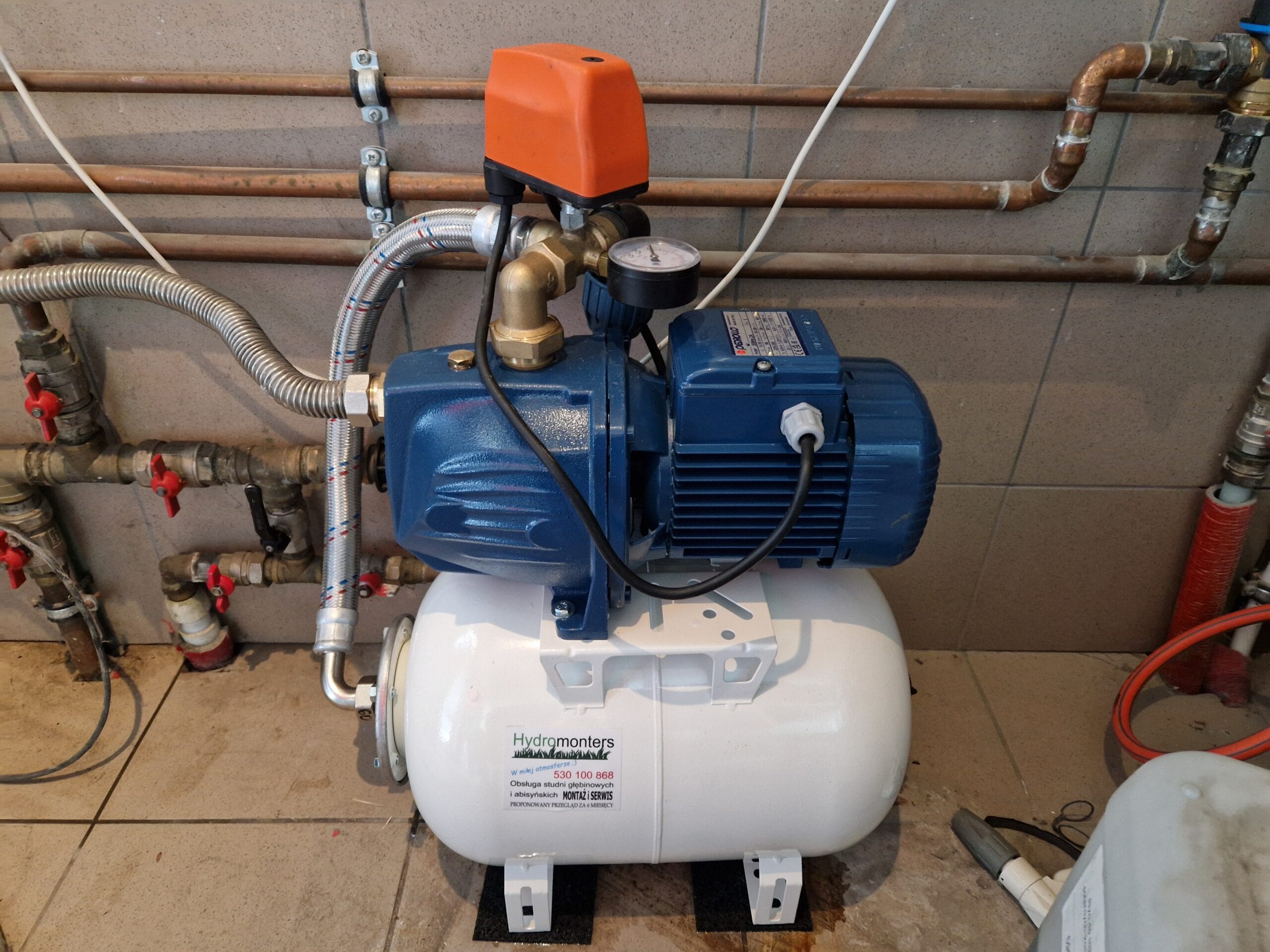 Wzorcowy montaż Hydromonters.pl: kompletny zestaw hydroforowy Pedrollo, w tym pompa, zbiornik i wyłącznik ciśnieniowy Pedrollo PSG (pomarańczowy).