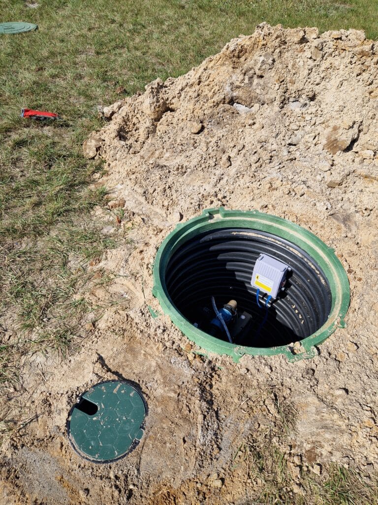 Zwieńczenie montażu studni głębinowej: obudowa z rury karbowanej tworząca suchą komorę rewizyjną dla głowicy studni i chroniąca ją przed zasypaniem.