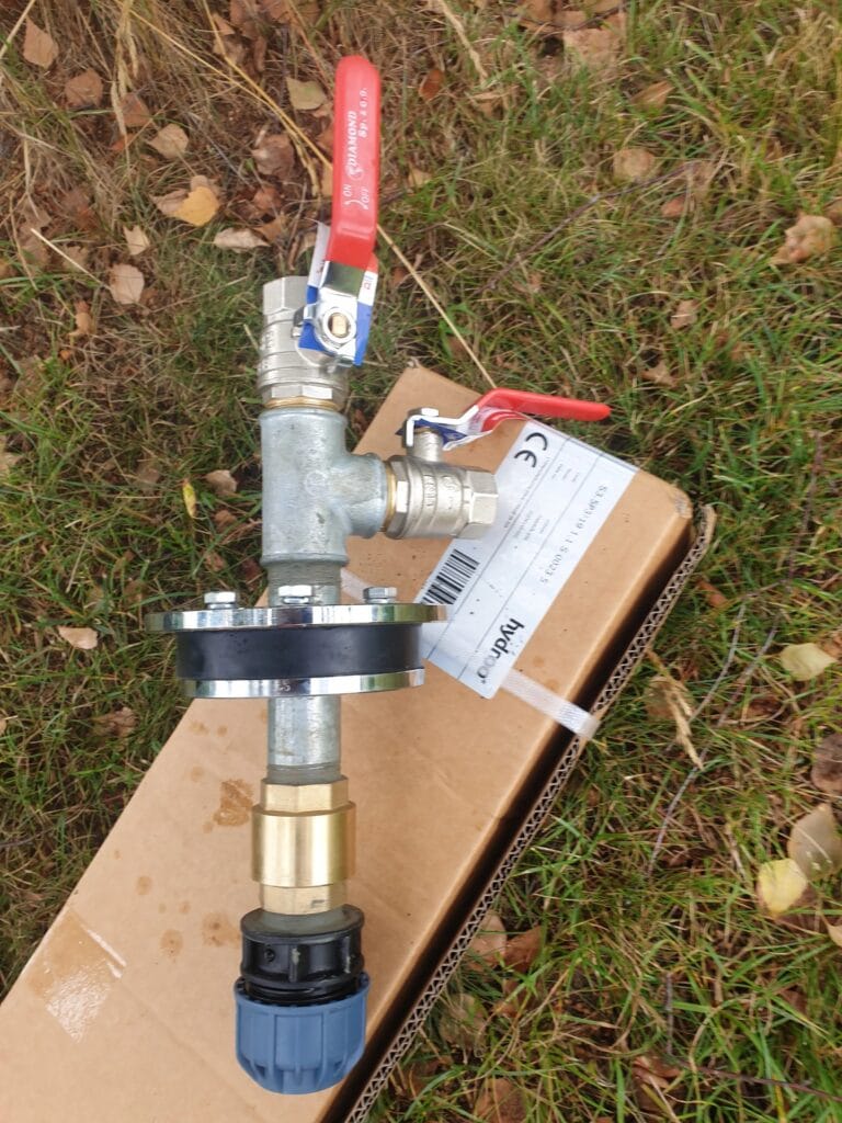 Zestaw głowicy hermetycznej studni głębinowej (Warszawa), "uzbrojony" w zawory kulowe DIAMOND i złączkę PE, leżący na kartonie Hydroo.