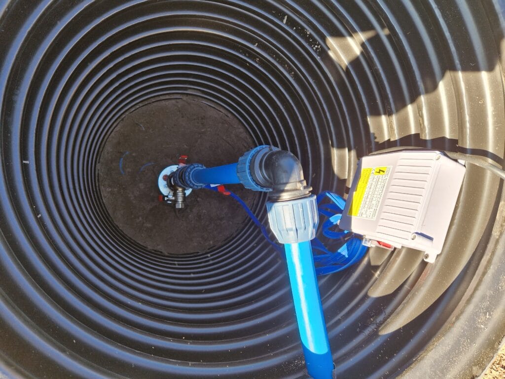 Satysfakcjonujący montaż hermetycznej głowicy studni głębinowej z przyłączem PE i czerwoną linką asekuracyjną ze stali nierdzewnej.