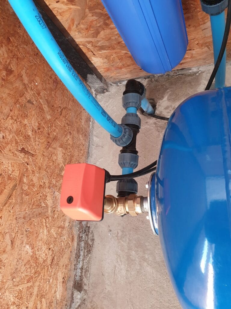 Pompownia systemu nawadniania (Warszawa): zbiornik przeponowy, wyłącznik Pedrollo PSG (pomarańczowy) i filtr sznurkowy, zasilane z pompy głębinowej.