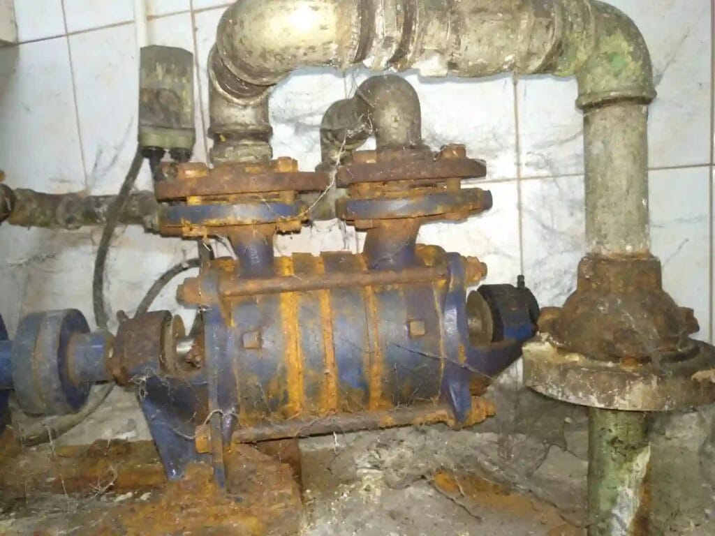 Krytyczna awaria: archaiczna pompa Hydro-Vacuum SKA w stanie całkowitego rozkładu korozyjnego, grożąca pęknięciem i zalaniem.