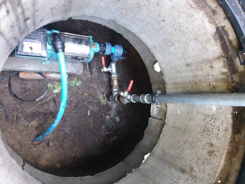 Kluczowy błąd: pompa powierzchniowa MHI 1300 zainstalowana w nieszczelnej, wilgotnej studni kręgowej, co gwarantuje jej zalanie i zniszczenie.