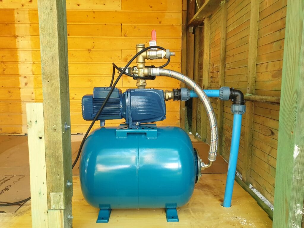 Montaż pompy Pedrollo JSWm 2A (lub JSW 2A) na działce letniskowej. Widoczna poprawna instalacja: sztywna rura ssąca (PE) i elastyczny wąż tłoczny (antywibracyjny).