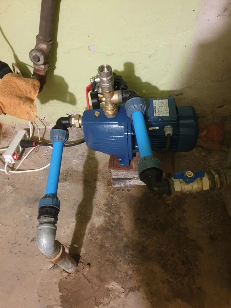 Montaż pompy Pedrollo JSWm w starej piwnicy (Warszawa), zintegrowanej ze starą instalacją "ocynk". Widoczny port do zalewania i ryzykowne zasilanie.