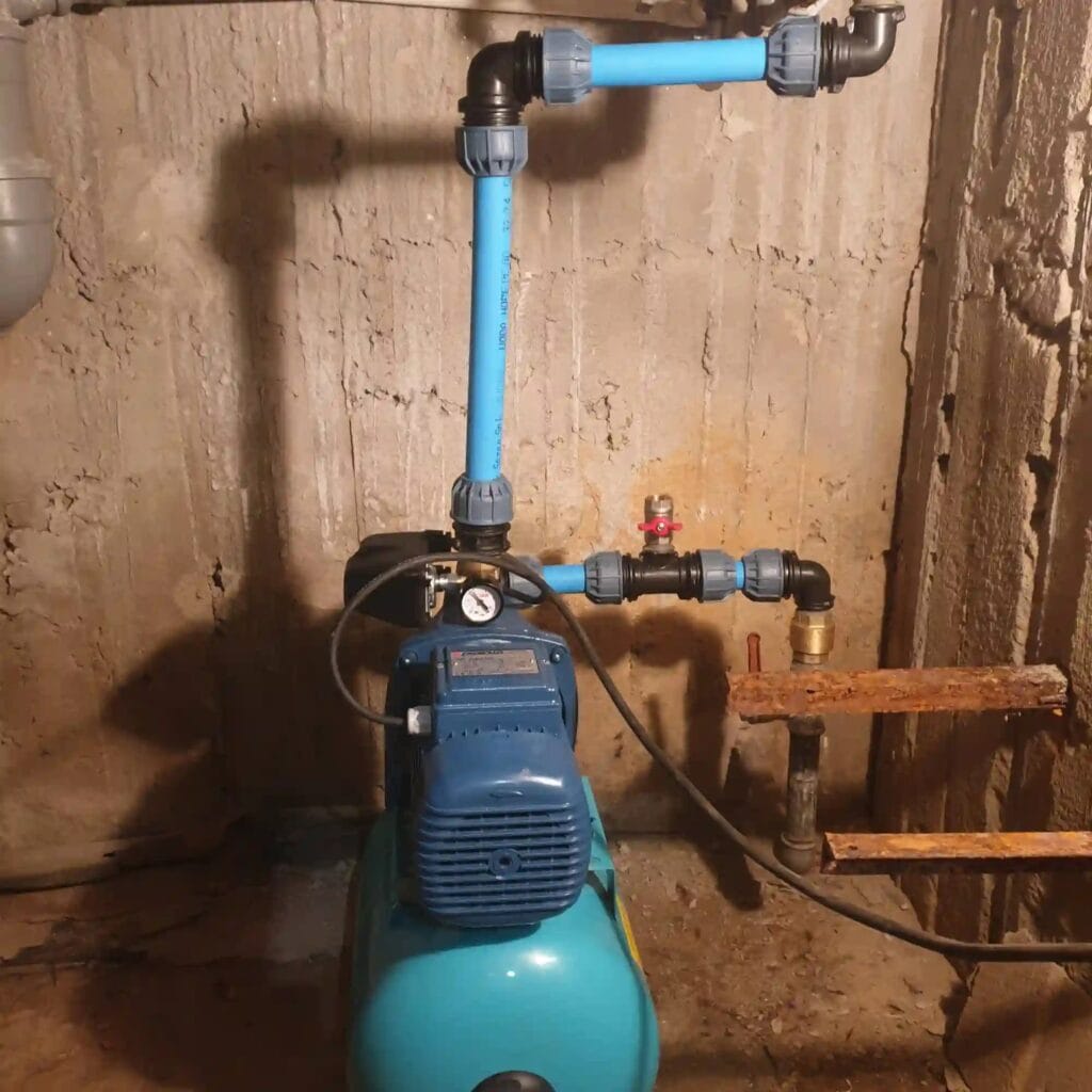 Montaż pompy Pedrollo JSWm (niebieska) ze zbiornikiem. Widoczny "smaczek techniczny": dedykowany port (zawór) do zalewania pompy na rurze ssącej.