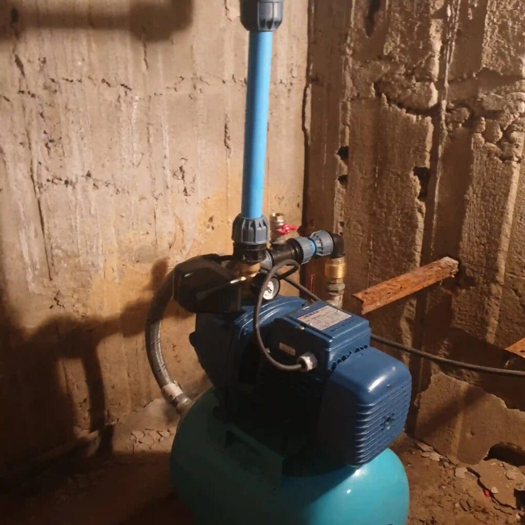 Pompa hydroforowa Pedrollo JSWm (niebieska) ze zbiornikiem, zainstalowana w piwnicy. Widoczny dedykowany zawór do zalewania na rurze ssącej.