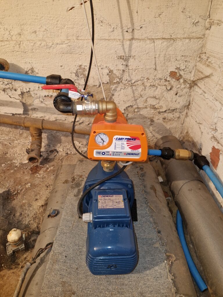 Instalacja pompy hydroforowej Pedrollo (niebieska) z nowoczesnym automatem sterującym Pedrollo EASY PRESS (pomarańczowy) w piwnicy.