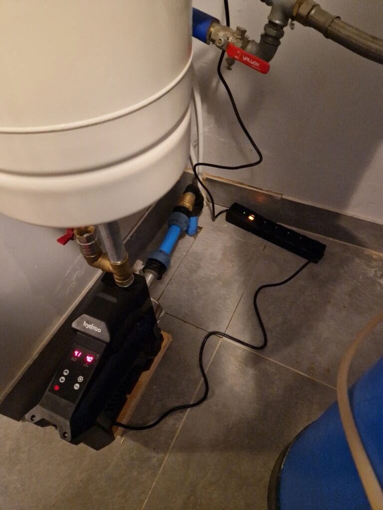 Zbliżenie na pompę Hydroo z zintegrowanym falownikiem (inwerterem) i wyświetlaczem cyfrowym, połączoną ze zbiornikiem buforowym PressureWave.