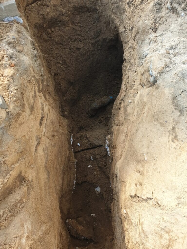 Ekstremalnie trudny, głęboki wykop ręczny pod przyłącze wodne w sypkim, piaszczystym gruncie (jak w Markach), grożącym ciągłym zasypywaniem.