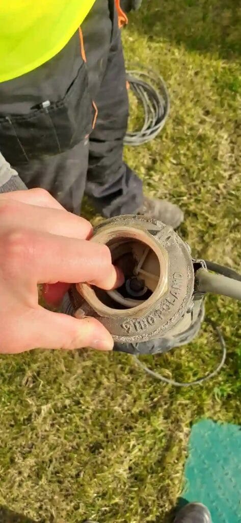 Zniszczona hydraulika pompy głębinowej. Serwisant wskazuje na uszkodzenia wirników spowodowane brakiem zewnętrznego zaworu zwrotnego.