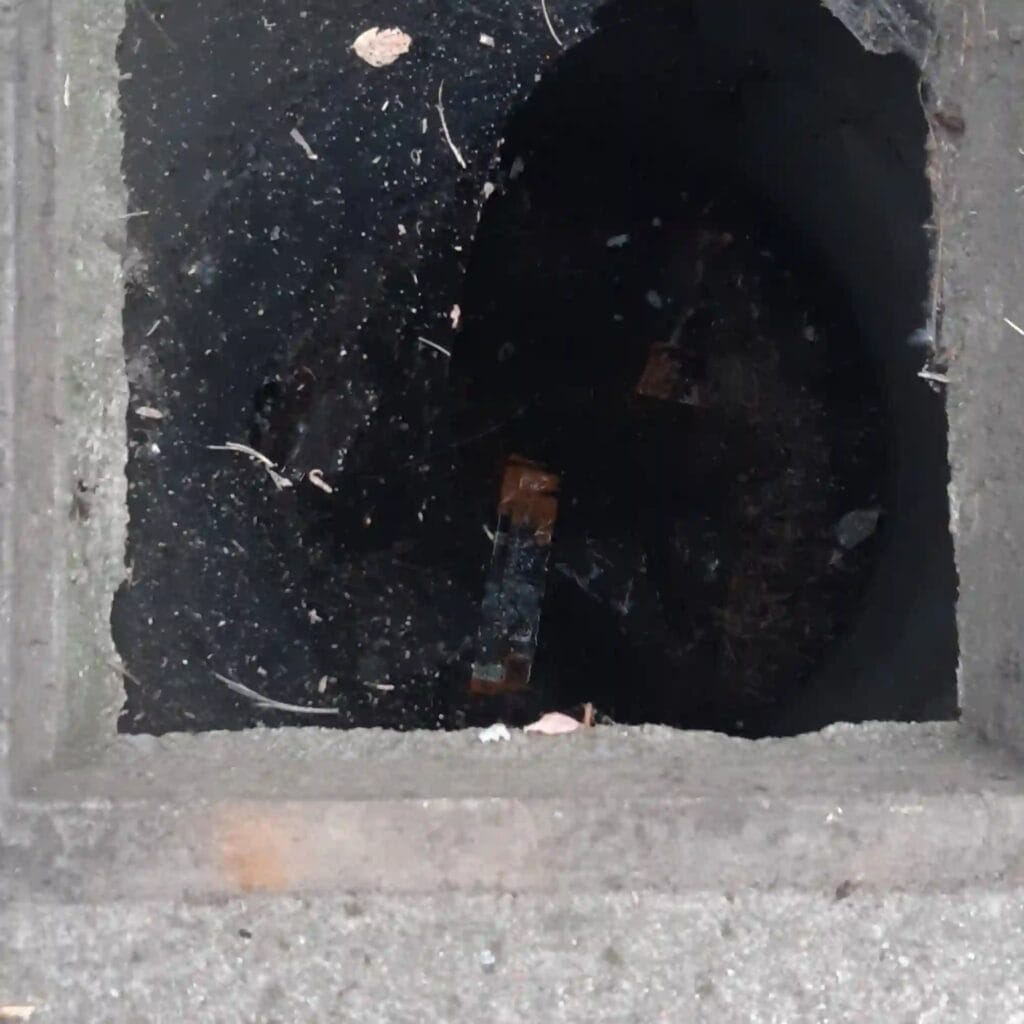 Zalana studnia kręgowa w rejonie Białołęki (Warszawa), z brudną wodą i zanieczyszczeniami na powierzchni. Obraz ilustrujący konieczność pilnej interwencji i czyszczenia studni.