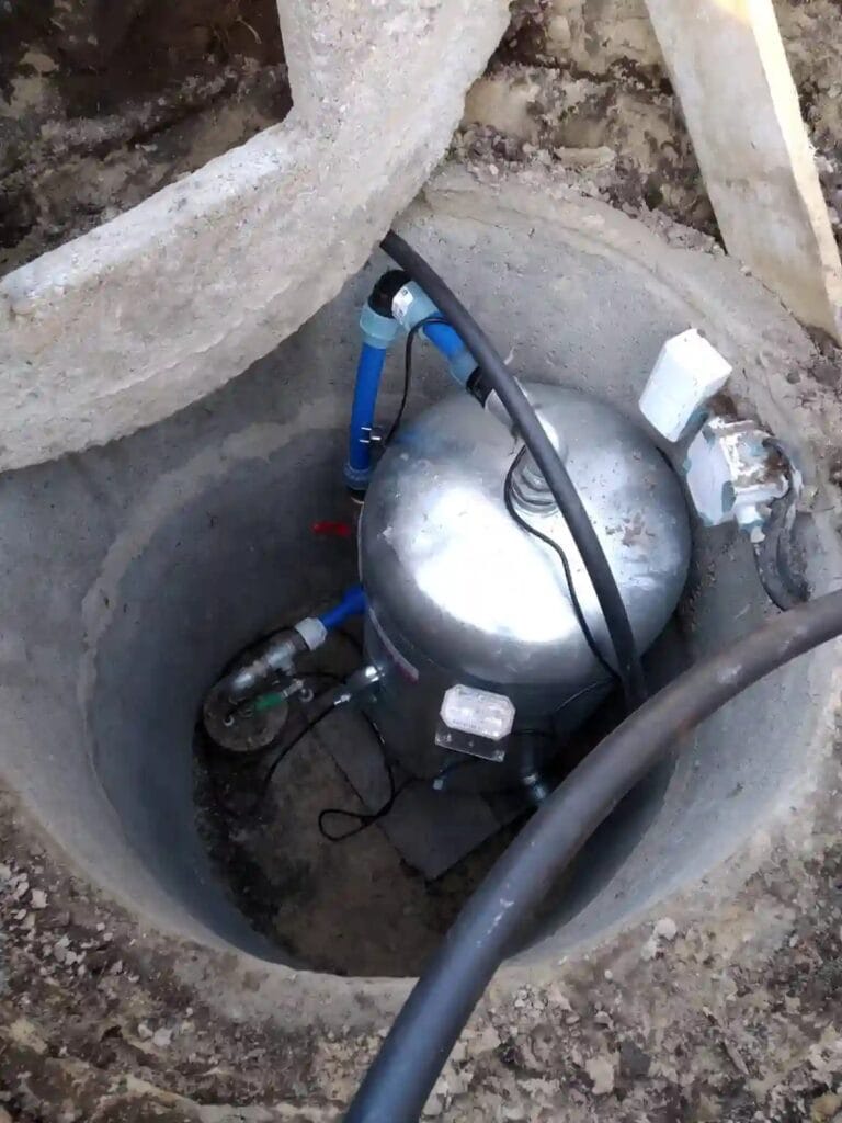 Nieprawidłowy montaż: duży zbiornik ocynkowany umieszczony w ciasnej studni kręgowej, co powoduje korozję i uniemożliwia serwis.