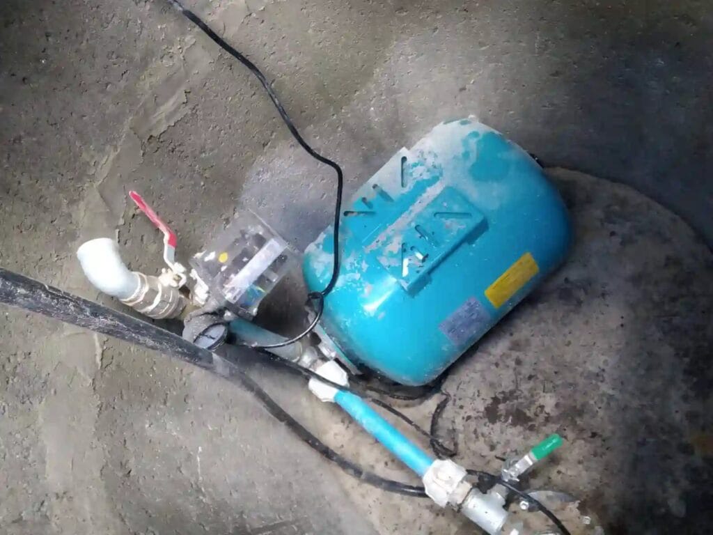 Błędny montaż: zbiornik przeponowy i mechaniczny wyłącznik ciśnieniowy zainstalowane w wilgotnej studni, co grozi awarią.