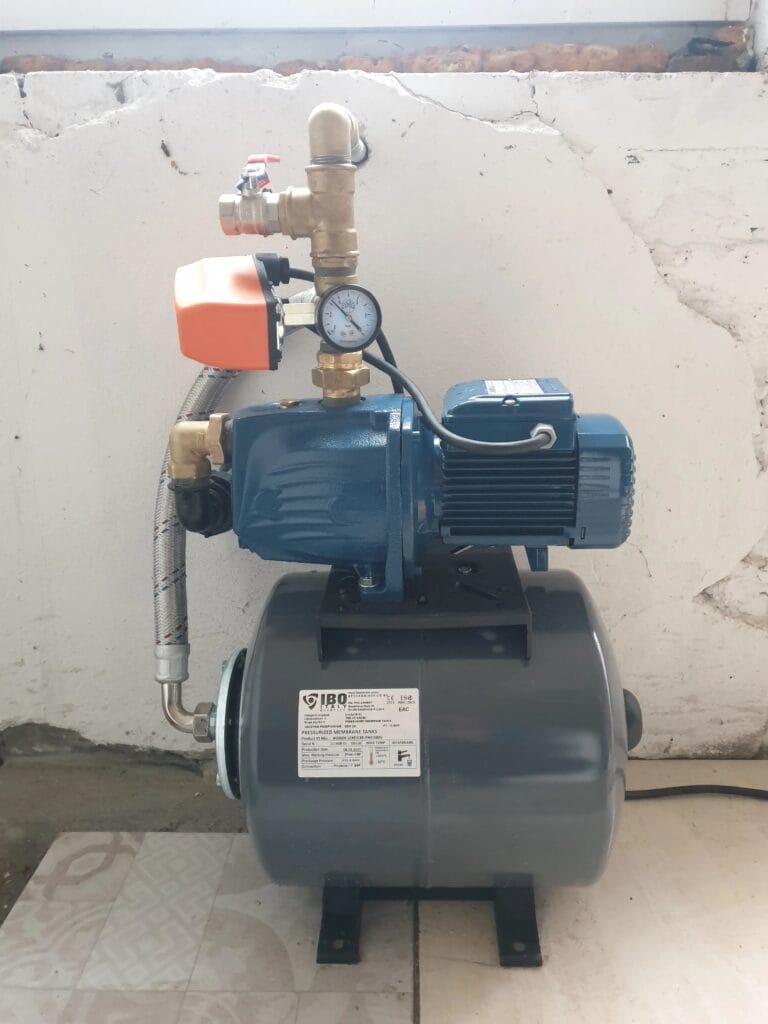 Klasyczny zestaw hydroforowy z pompą Pedrollo JSWm 2A, włoskim wyłącznikiem ciśnieniowym PSG-1 i manometrem, zamontowany na niebieskim zbiorniku przeponowym.